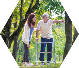 Asian senior man with walker and his daughter walking together in the park looking for beautiful nature and wildlife during summer for light exercise and physical therapy