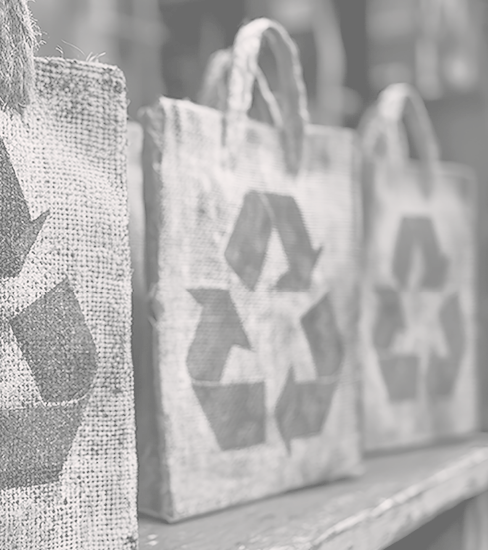 A set of burlap tote bags featuring green recycling symbols, promoting sustainable living. Perfect for eco-conscious shopping and reusable purposes.