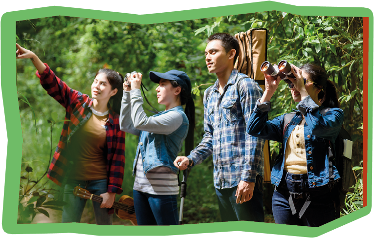 Group of friends walking on an adventure in the forest Look at the map to explore the forest and plan as a team.
