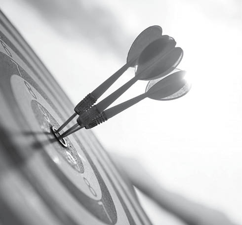 Close up shot red darts arrows in the target center on dark blue sky background. Business target or goal success and winner concept.