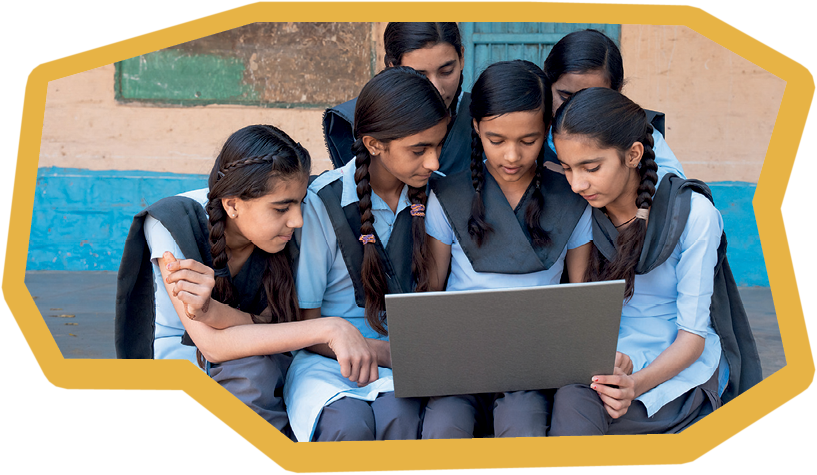 Group of rural school girls in uniform sitting in school corridor working on laptop - concept of digital education