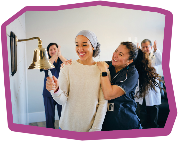 An adult woman chemotherapy patient in a treatment office, celebrating the completion of her treatment with a ceremonial bell ring. Actor portrayal.