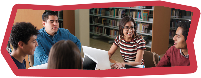 Smiling students talking to each other in the library a long with a group of friends.