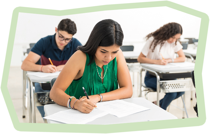 Confident student writing exam in classroom at high school