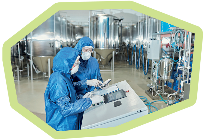 Side view portrait of two workers operating equipment at factory and using control panel